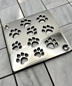 Square drain with dog paws design in polished stainless steel finish.