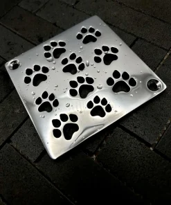 Square drain with dog paws design in polished stainless steel finish.