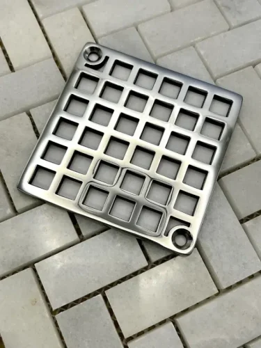 Square drain with Geometric squares 7 design in polished stainless steel finish.